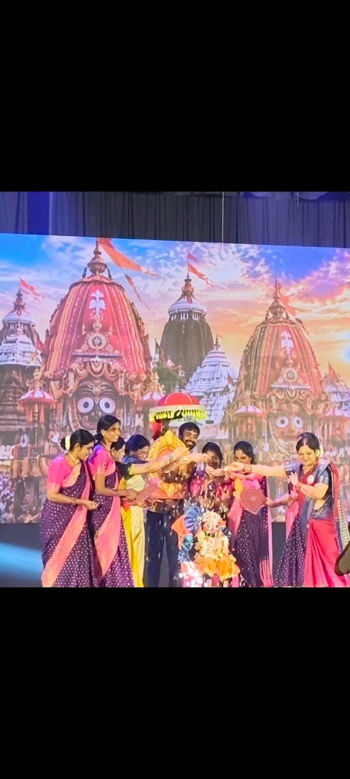 Children performing on stage in front of the Jagannath Puri temple backdrop
